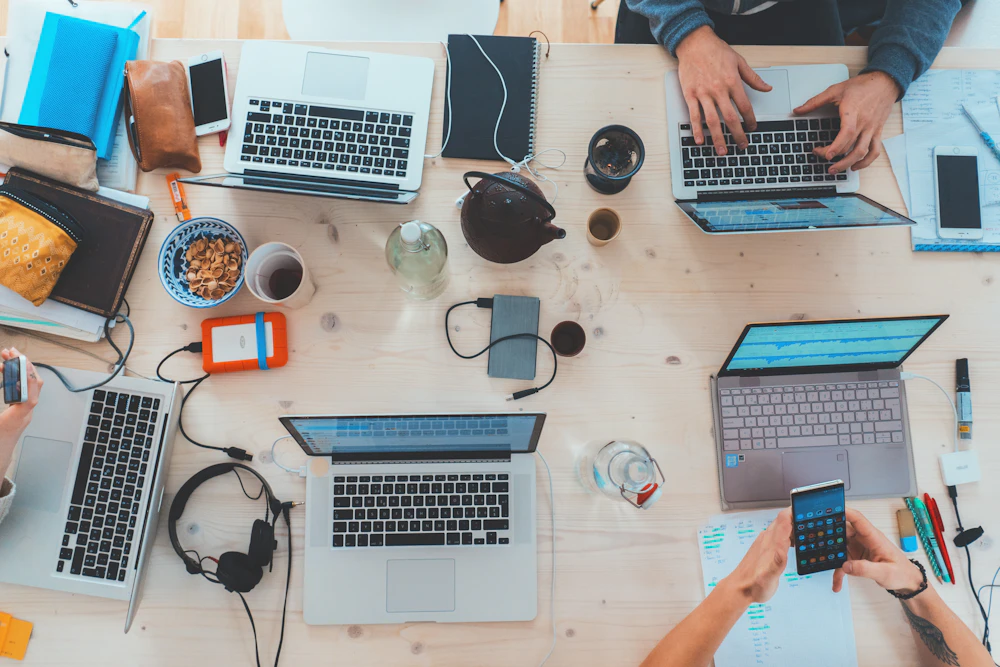 A shared table with notebooks and laptops; illustrative photograph, not a photo of the 2024 event.
